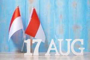 texto de madera del 17 de agosto con banderas de indonesia en miniatura. día de la independencia de indonesia, día festivo nacional y conceptos de celebración feliz foto