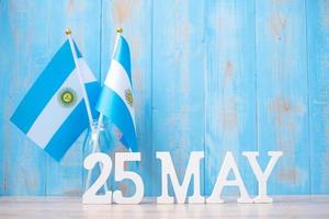 texto de madera del 25 de mayo con banderas argentinas. día de la revolución argentina y conceptos de celebración feliz foto