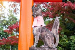 Fox sculpture in Fushimi Inari-taisha shrine in fall autumn season, located in Fushimi-ku. landmark and popular for tourists attractions in Kyoto. Kyoto, Japan, 27 November 2019 photo