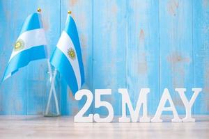 texto de madera del 25 de mayo con banderas argentinas. día de la revolución argentina y conceptos de celebración feliz foto