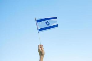 hand holding Israel flag on nature background. Israel Independence day and happy celebration concepts photo