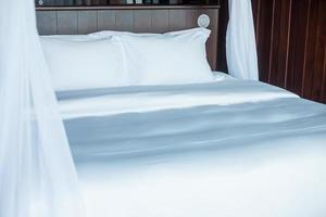 almohadas limpias en la cama en una habitación de hotel de lujo o en una casa moderna. conceptos de dormir, relajarse y vacaciones foto