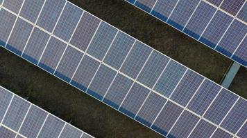 prise de vue au ralenti, vue aérienne par drone, vol au-dessus d'une ferme de panneaux solaires, énergie alternative verte renouvelable par panneaux de cellules solaires avec lumière du soleil video
