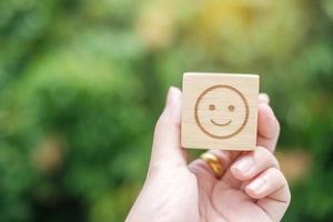 Smile emotion face symbol on wooden blocks. Service rating, ranking, customer review, satisfaction, evaluation and feedback concept photo