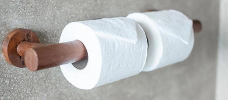 Woman hand pulling toilet paper in restroom. Cleaning, Lifestyle and personal hygiene concept photo