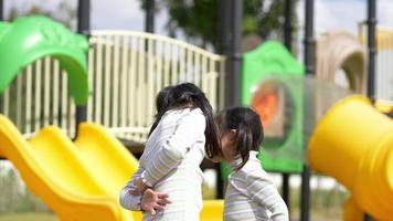 Slow motion, Two lovely girls sharing chewing fruit gum with fun in playground video