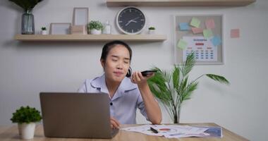 portret van een glimlachende zelfverzekerde aziatische zakenvrouw die een audiobericht opneemt op de mobiele telefoon, de virtuele assistent vocaal commando geeft voor online zoeken, de app voor spraakherkenning gebruikt en spreekt. video