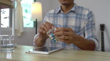 asian men take a drug in living room. futuristic medication dose hologram technology. video