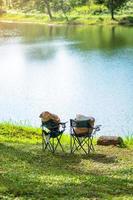 dos sillas acampando cerca del lago. concepto de viaje, viaje y vacaciones al aire libre foto