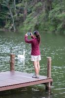 mujer viajera feliz tomando fotos de la naturaleza por teléfono inteligente, turista sola en suéter viajando en pang oung, mae hong son, tailandia. concepto de viaje, viaje y vacaciones