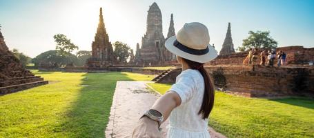 Tourist Woman in white dress holding her husband by hand and walking to ancient stupa in Wat Chaiwatthanaram temple in Ayutthaya Historical Park, summer, together, follow me, Asia and Thailand travel photo