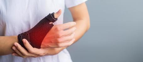woman holding her wrist pain because using smartphone or computer long time. De Quervain's tenosynovitis, Intersection Symptom, Carpal Tunnel Syndrome or Office syndrome concept photo