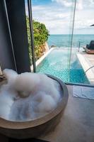 the bathtub with bubble foam against ocean background. Summer, relaxing and vacation concepts