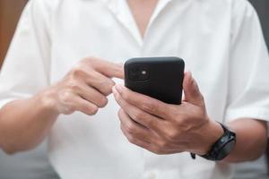 Man using smartphone for social media, young male texting messages by mobile phone. technology, network, online shopping, e commerce, lifestyle and digital communication concept photo