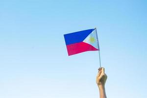 mano sosteniendo la bandera de filipinas en el fondo de la naturaleza. 12 de junio del día de la independencia y conceptos de celebración feliz foto