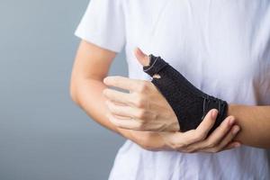 woman holding her wrist pain because using smartphone or computer long time. De Quervain's tenosynovitis, Intersection Symptom, Carpal Tunnel Syndrome or Office syndrome concept photo