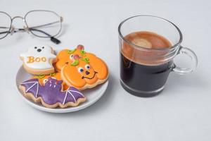 café expreso caliente o taza de chocolate con divertidas galletas de halloween. feliz día de halloween, truco o amenaza, hola octubre, otoño otoño, tradicional, concepto de fiesta y vacaciones foto