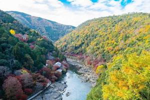 montañas de hojas coloridas y río katsura en arashiyama, hito del paisaje y popular para las atracciones turísticas en kyoto, japón. otoño temporada de otoño, vacaciones, vacaciones y turismo concepto foto