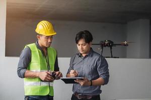 Construction workers discussing about workplan on building site. contruction worker talking about workplan with drone on site. photo