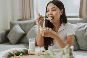 Healthy woman eating healthy food. Young woman cooking healthy food at home. Healthy and wellness concept. photo