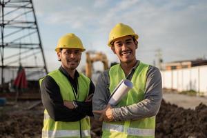 Engineers men working in building site. Asian worker men smiling and crossed arms in construction site. photo