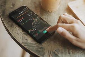 Trader investor discussing and analysis graph on smartphone. business woman using mobile phone app analytics for cryptocurrency. photo
