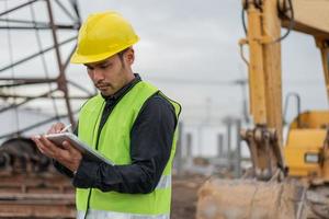 hombre ingeniero trabajando en el sitio de construcción. hombre trabajador asiático que trabaja en el sitio de construcción. foto