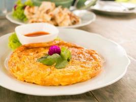 Tasty omelet with chilli sauce on plate. photo