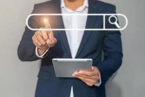 Businessman click search engine. businessman click search button and holding tablet. photo