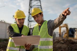 Engineers working on building site. Construction manager and engineer meeting and discussion about project in construction site. photo