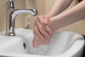 higiene. limpieza de manos. lavarse las manos con agua limpia. mano de mujer protéjase de la pandemia del coronavirus covid-19. cerca de la foto