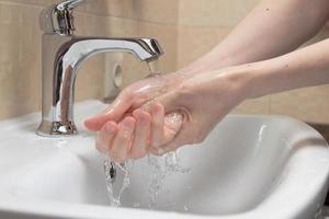 higiene. limpieza de manos. lavarse las manos con agua limpia. mano de mujer protéjase de la pandemia del coronavirus covid-19. cerca de la foto