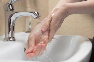 Hygiene. Cleaning Hands. Washing hands with clean water. Woman's hand. Protect yourself from coronavirus COVID-19 pandemia. Close-up photo