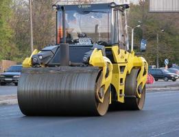 Ukraine, Kharkiv, October 27, 2020. Close-up view on the workers and the asphalting machines. Roller and workers on asphalting and repair of city streets. High quality photo