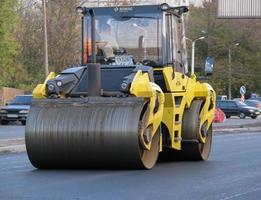 Ukraine, Kharkiv, October 27, 2020. Close-up view on the workers and the asphalting machines. Roller and workers on asphalting and repair of city streets. High quality photo