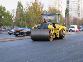 Ukraine, Kharkiv, October 27, 2020. Close-up view on the workers and the asphalting machines. Roller and workers on asphalting and repair of city streets. High quality photo