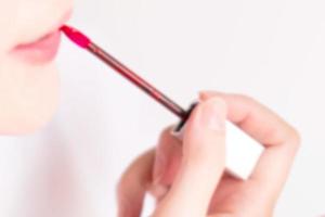 A woman are making up by lipstick in blurry effect. photo