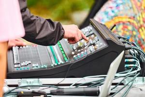 Sound engineer hand adjusting audio mixer at live concert, stage sound mixer, audio mix slider photo