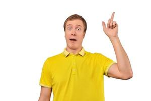 Funny young guy in yellow T-shirt with eureka gesture, man got idea, isolated white background photo