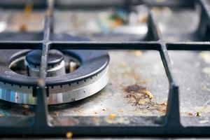 Dirty gas stove with food leftovers and crumbs photo