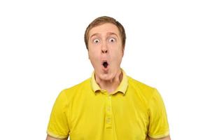 Surprised young man with funny facial expression in yellow T-shirt, white isolated background photo