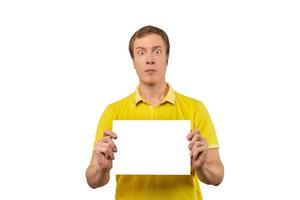 Surprised young man holding blank paper sheet, paper mockup isolated on white background photo
