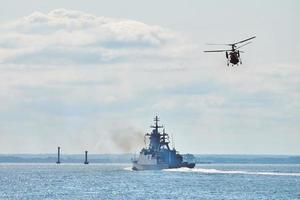 Battleship war ship corvette during naval exercises and helicopter maneuvering over sea, warships photo