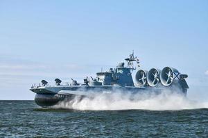 Landing Craft Air Cushion hovercraft flying above water, air cushion sailing splashing sea water photo