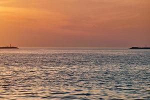 Calm sea with sunset sky, beautiful scenic view, amazing dramatic rising sun reflected in water photo