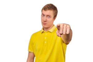 Un chico guapo con una camiseta de polo amarilla casual apuntando hacia adelante aislado de fondo blanco foto