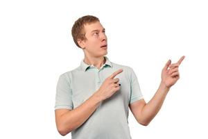 Surprised male with funny facial expression in mint Polo T-shirt pointing finger to right, isolated photo
