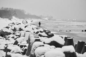 rompeolas de hormigón cubiertos de nieve, fondo de mar de invierno foto