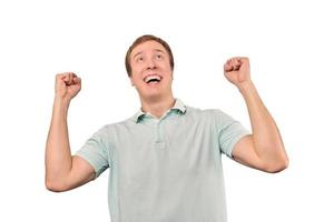 Successful smiling guy in mint T-shirt rejoices success, white background, triumph achievement photo