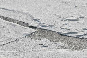 Cracked ice of frozen lake, ice texture background photo